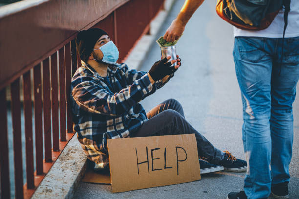 Homeless man with cardboard sign receiving money donation